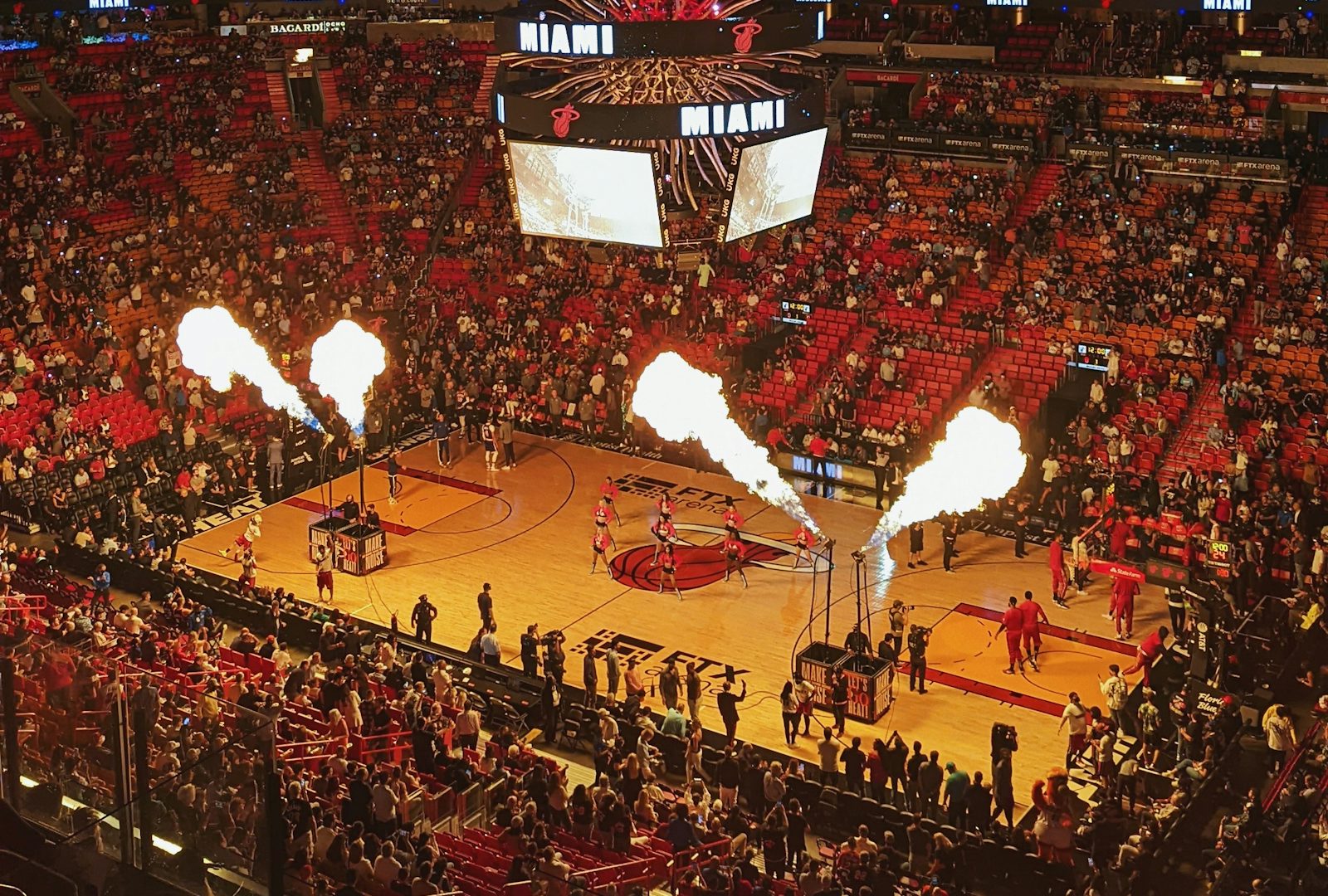 A large crowd filling the stands around a basketball court