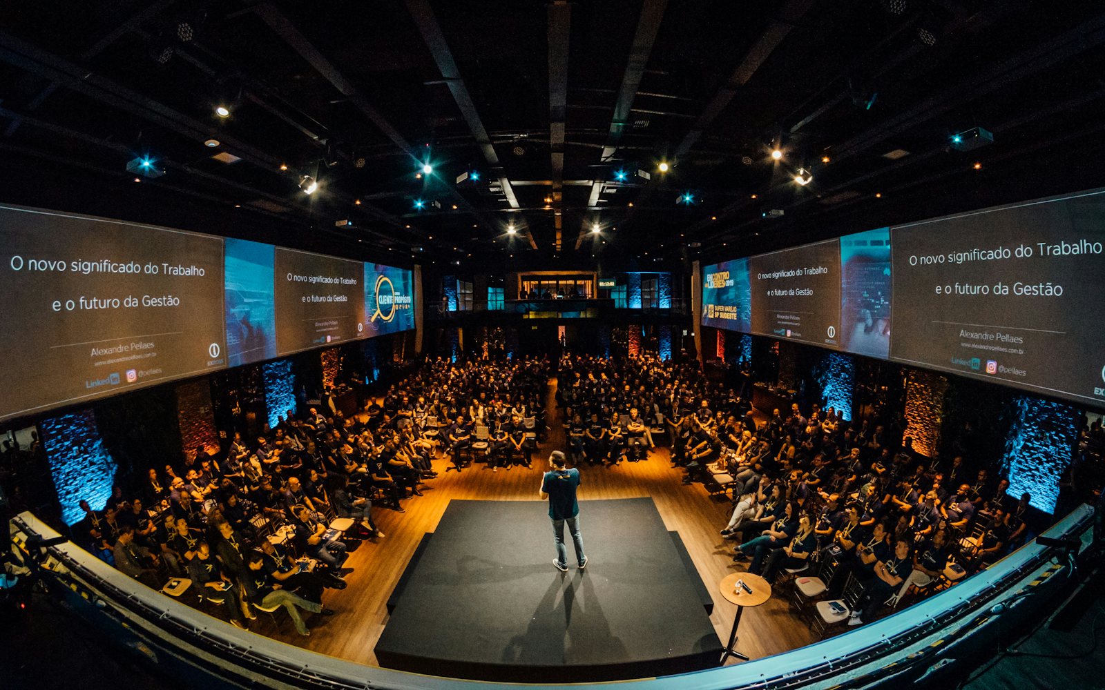 A speaker on stage addressing a large audience